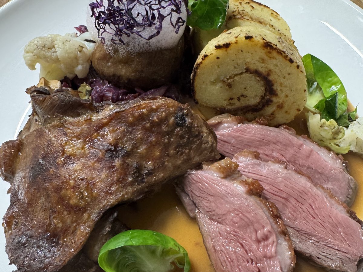 Weidegansl with red cabbage, a potato and lingonberry roulade and brussels sprouts